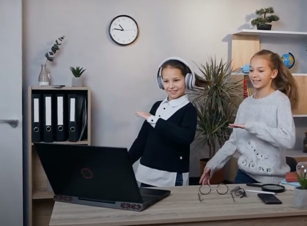 Two kids in front of computer taking a virtual art class
